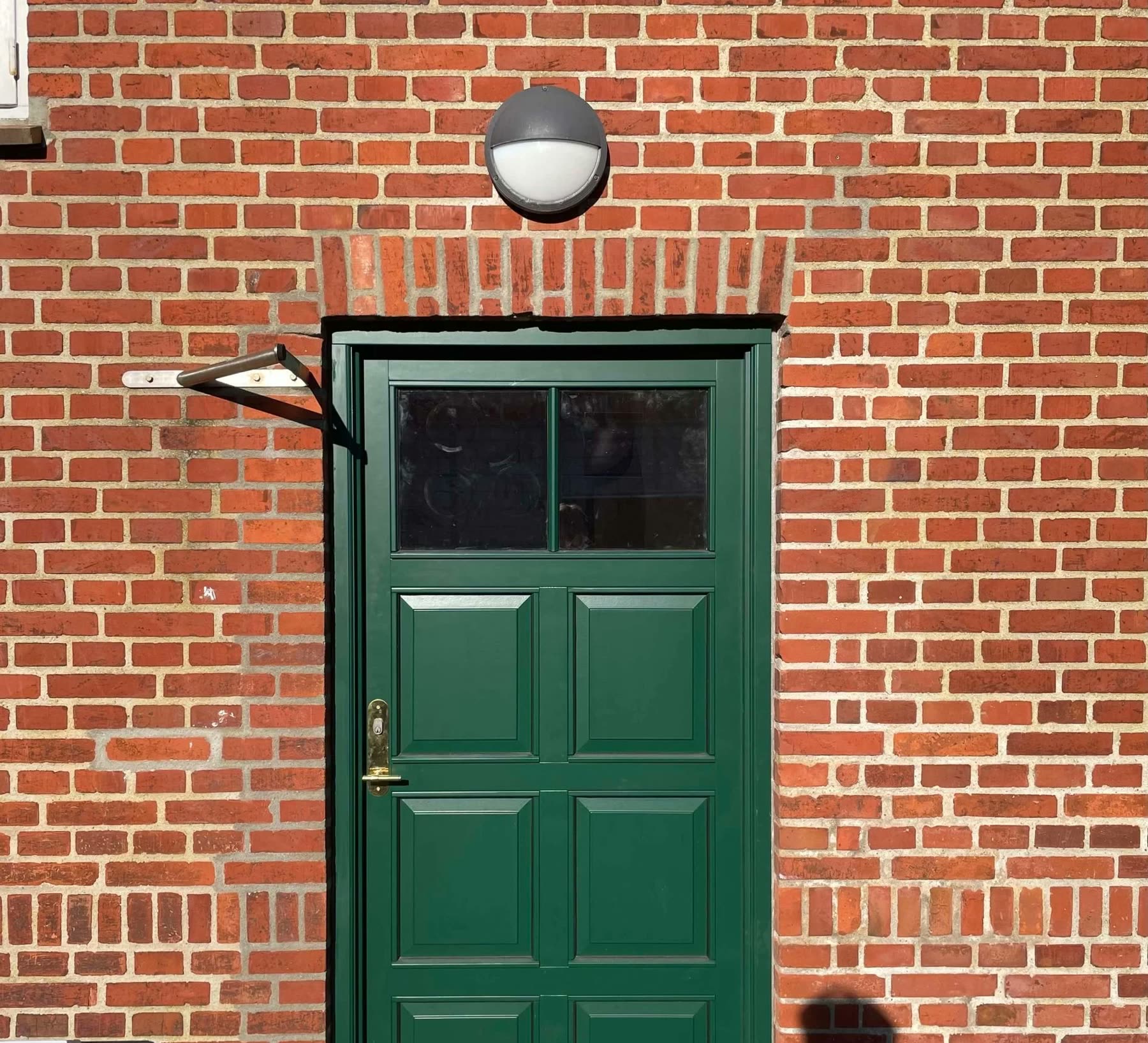 Grøn fyldningsdør med glas.