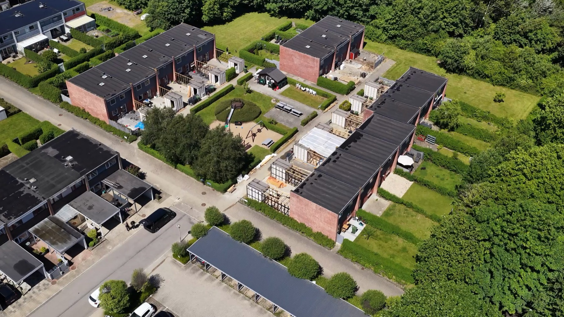 Rækkehusene og haverne fra luften i juni.